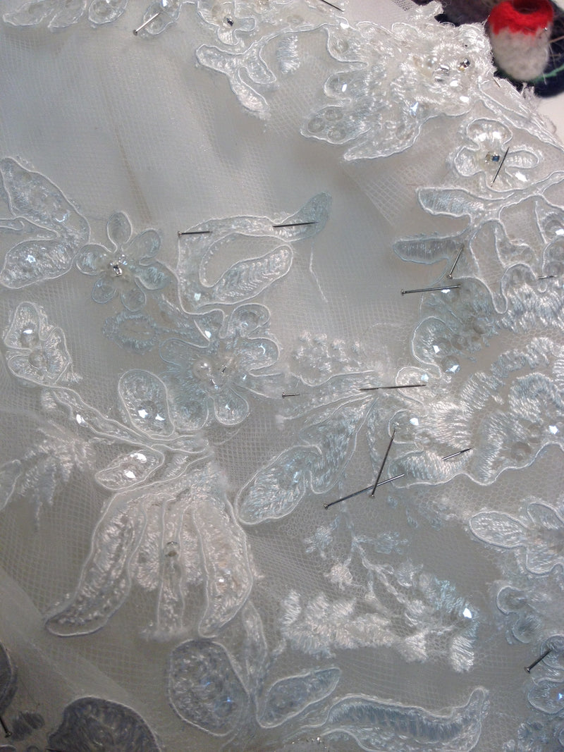 Dentelle brodée de perles, fixée à l’épingle avant la couture